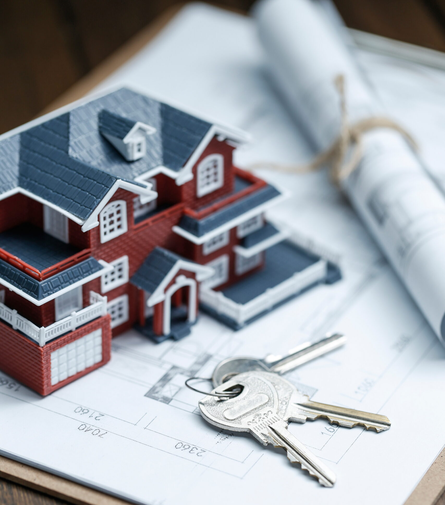 Villa house model, key and drawing on retro desktop (real estate sale concept)